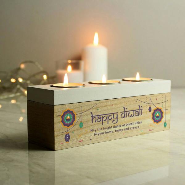 A personalised wooden triple tealight holder printed with 'Happy Diwali' and a custom message blessing, with three lit candles glowing warmly.