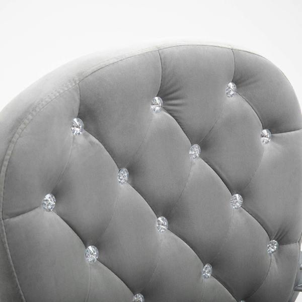 Grey velvet chair backrest close-up with button tufting and curved head support