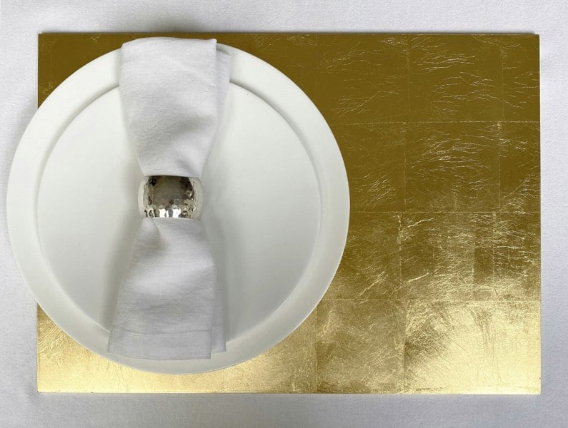 grand gold leaf placemat beneath plates and napkin