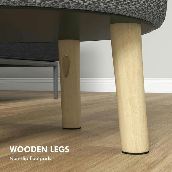 Light grey round ottoman showing tapered wooden legs and non-slip footpads
