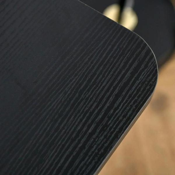 Black textured tabletop surface close-up with curved rounded edge
