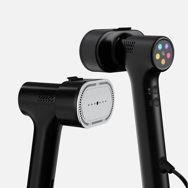 Two black Fridja f20 Handheld Clothes Steamer Pro with Suction devices are featured. One unit highlights a control panel with colored buttons, while the other showcases the ironing plate equipped with multiple small holes. Both garment steamers present a sleek, modern design set against a plain background.