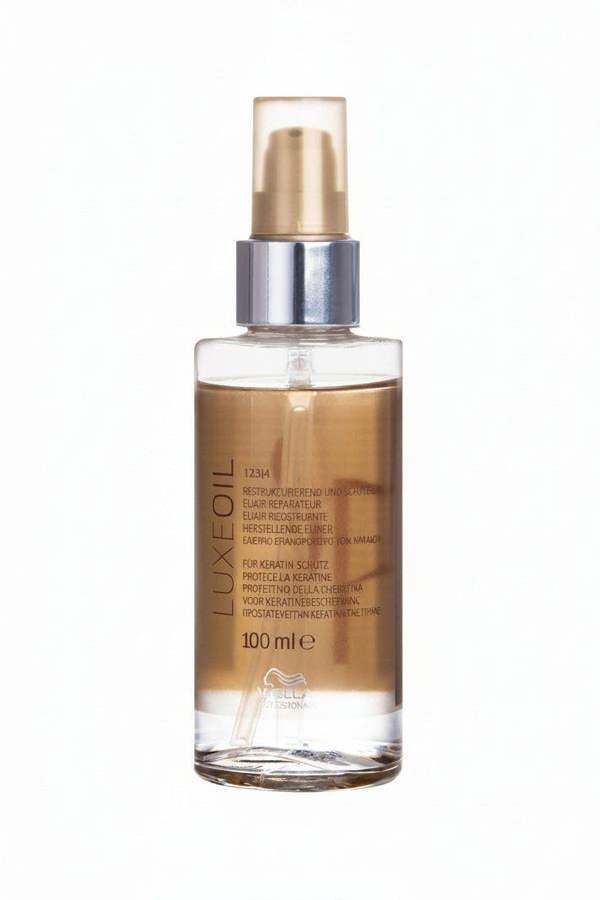 LuxeOil hair oil bottle with gold cap on a white background