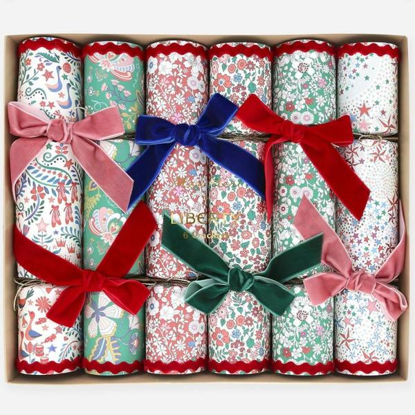 Set of six Liberty print party crackers neatly packaged inside a presentation gift box, tied with plush velvet bows in red, green, blue, and pink.