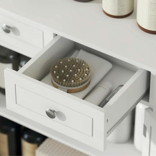 Close-up of white bathroom cabinet drawer with metal knob and open storage compartment