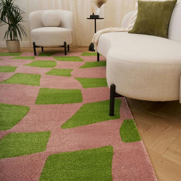 Living room with a pink and green checkered rug, beige sofa, and white armchair.