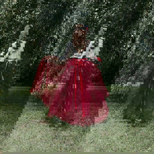 Person wearing a red dress with a white lace top in a park setting
