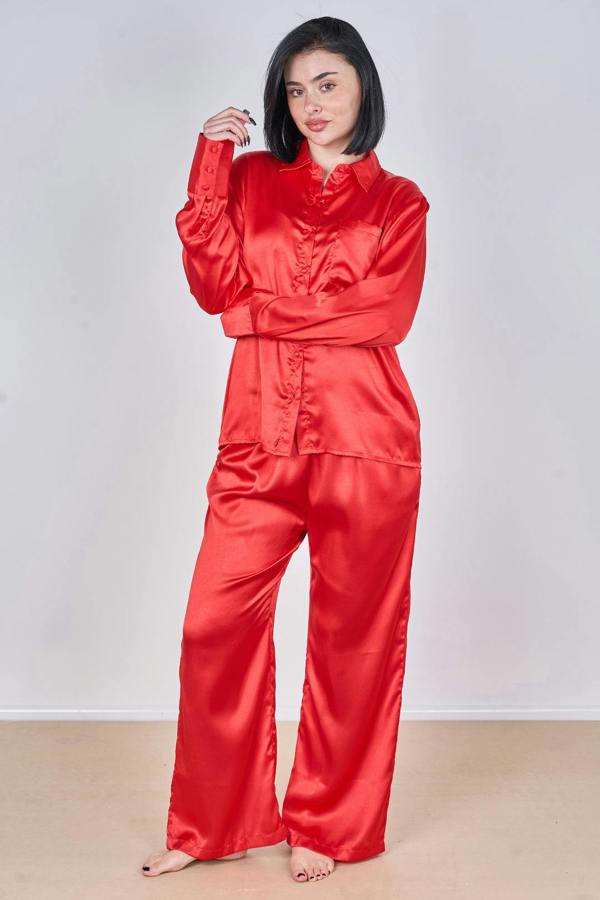 Woman wearing a red satin pajama set against a plain background