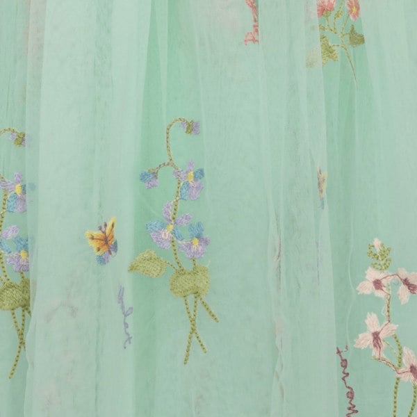 Embroidered fabric with floral and butterfly designs on a light green background