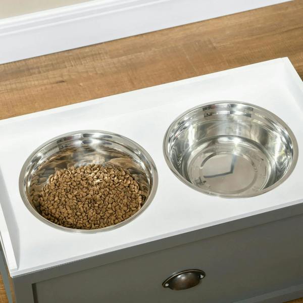 Close-up of grey raised feeding station with two stainless steel bowls and drawer handle.