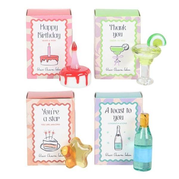 Close-up of glass charm tokens: cake, star, toast bottle and thank-you card inserts.