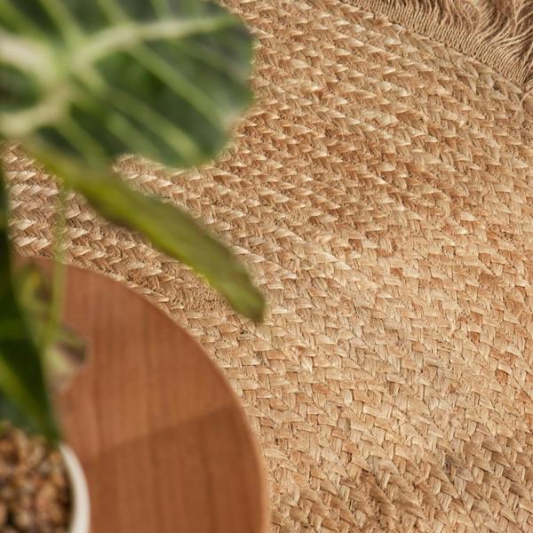 Close-up of a woven mat with a plant in the foreground