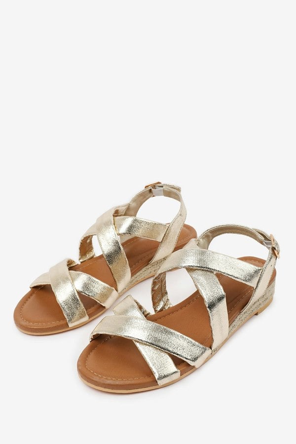 Where's That From Violet Wide Fit Low Wedge Shoes With Buckle Closure & Cross Over Strap in Gold Metallic Faux Leather