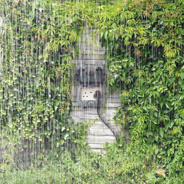 ENER-J IP65 outdoor waterproof socket installed on garden wall during heavy rain