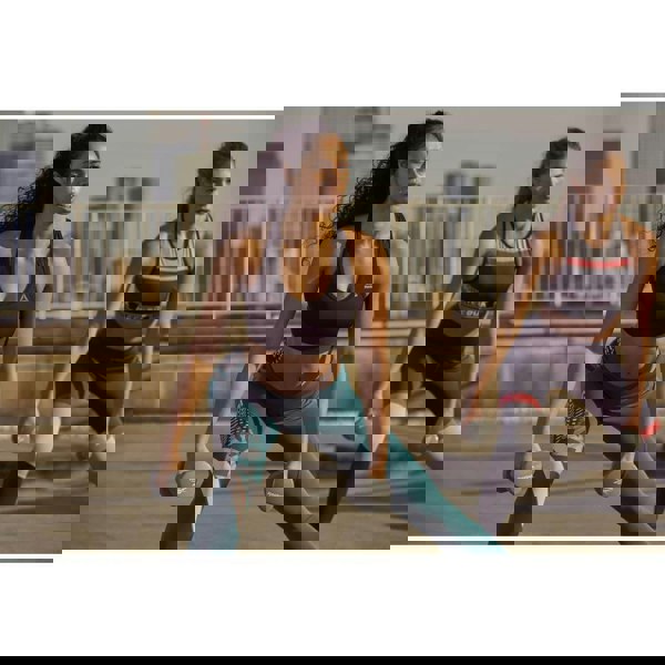 Two women exercising outside using Reebok 3kg Dumbbells