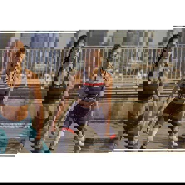 Two women outside exercising using Reebok 3kg Dumbbells