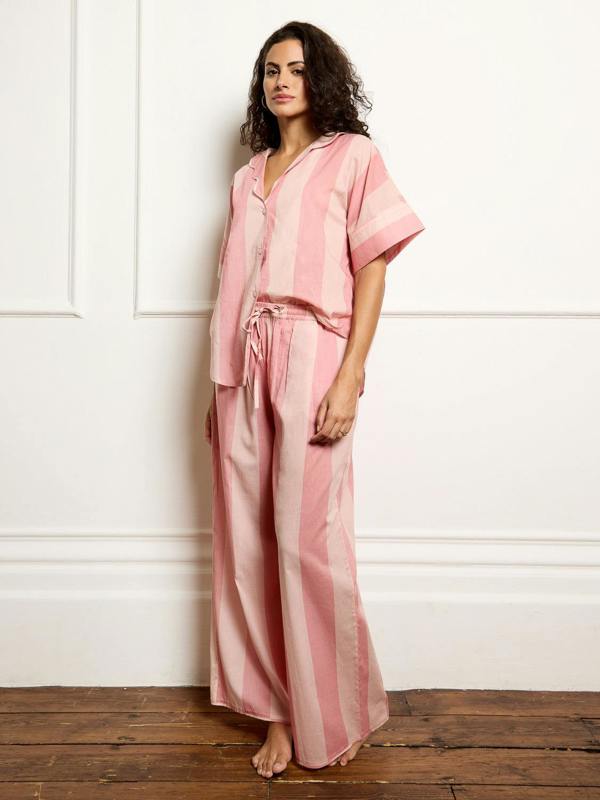 Model wears cotton pink stripe Their Nibs pyjamas, full length