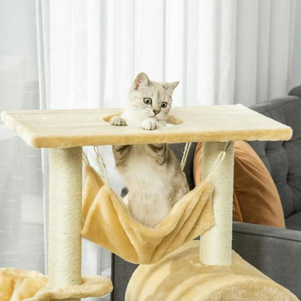 Beige cat tree tower with top platform and hanging hammock with a resting cat