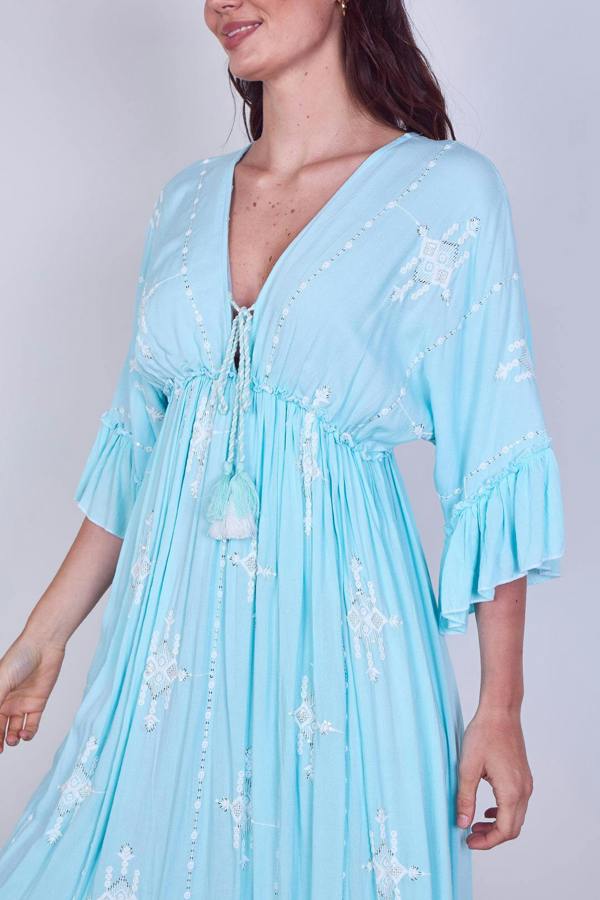 Light blue dress with floral patterns worn by a model on a plain background