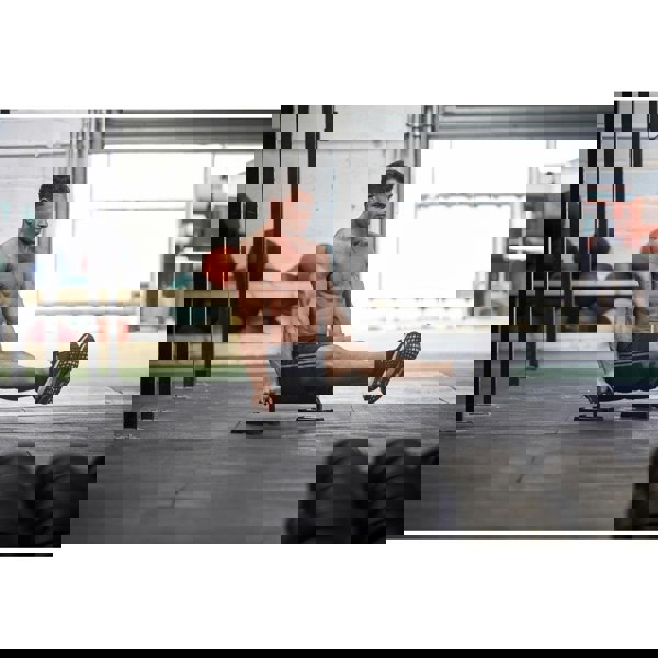 Man exercising using the Adidas Premium Push Up Bars in the gym