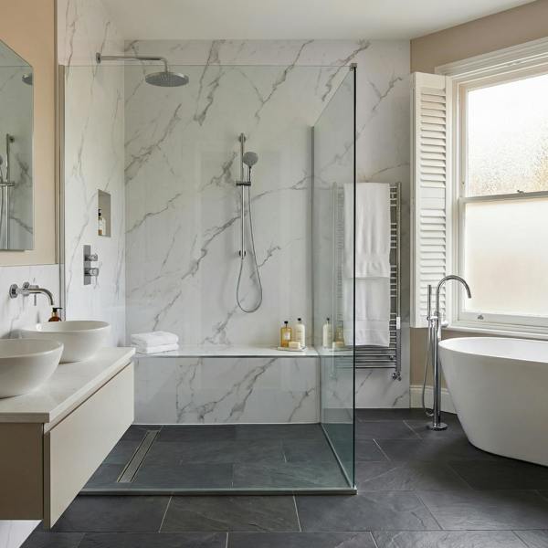 Modern bathroom with carara white pvc wall panels, a freestanding bathtub, and a glass shower enclosure.