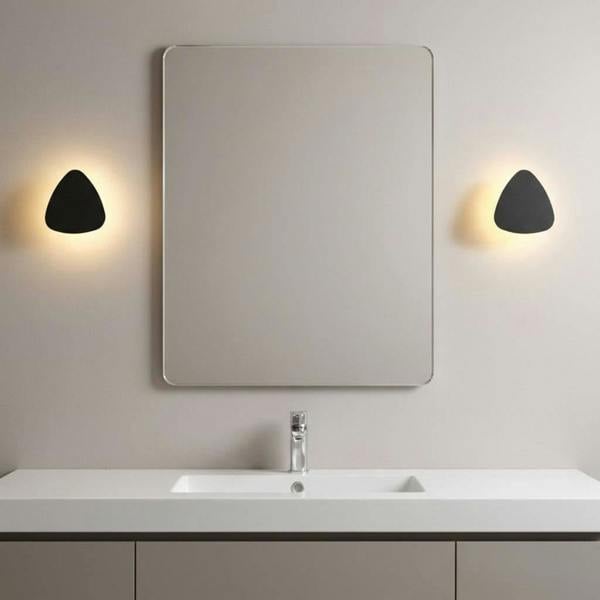 black bathroom sconce light mounted either side of the mirror above a bathroom vanity 