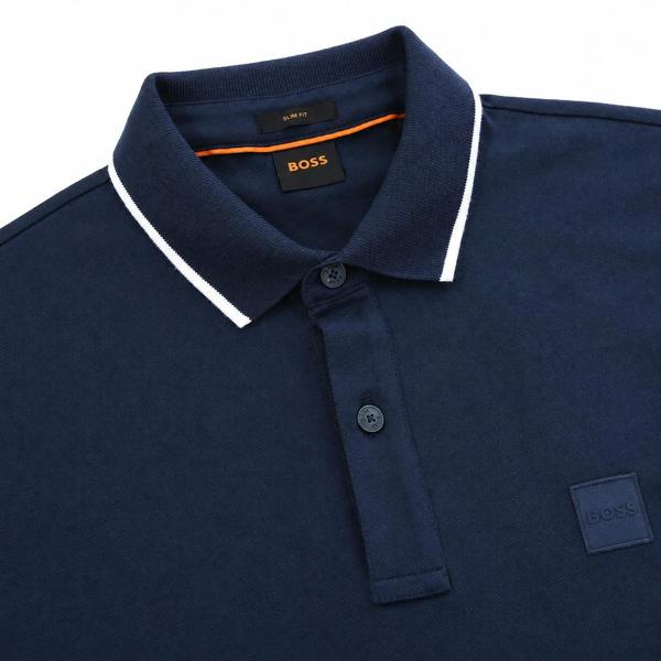 BOSS slim fit navy blue polo shirt with white tipped collar, button placket, and tonal logo patch on the chest.