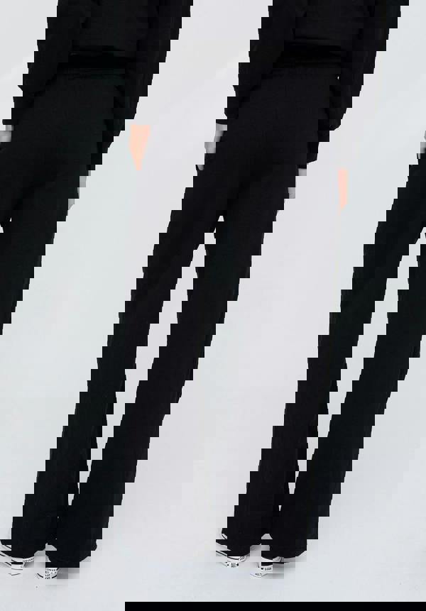 Person wearing black pants on a white background