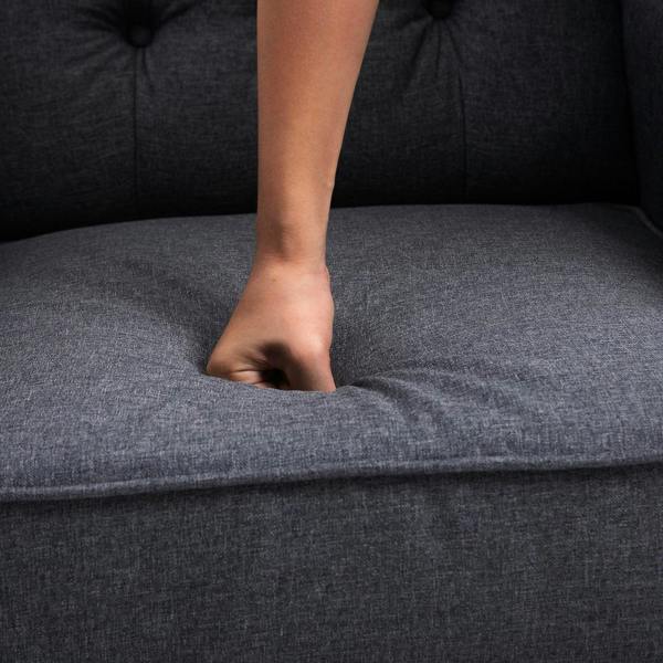 Dark grey recliner seat cushion with padded upholstery, hand pressing the fabric