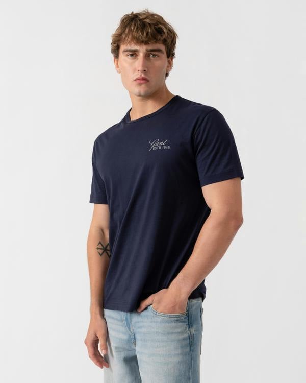 Model wearing GANT Mens Short Sleeve Small Graphic Logo T-Shirt - 433 Evening Blue