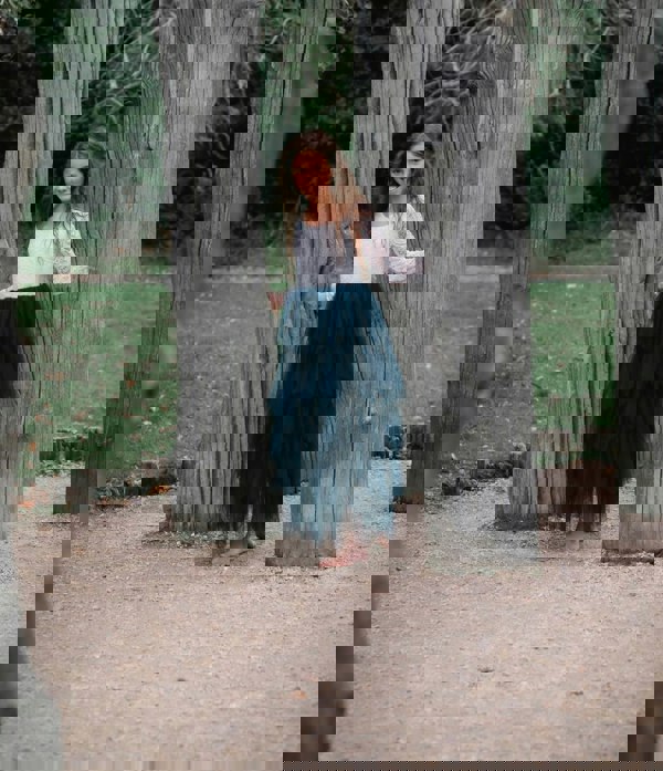 young girl holding to trees
