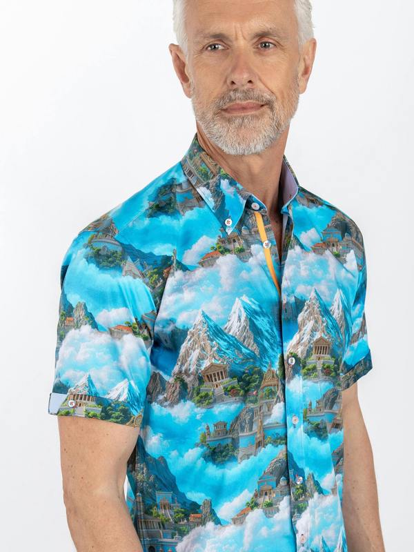 Man wearing a colorful shirt with a mountain and cloud design on a white background