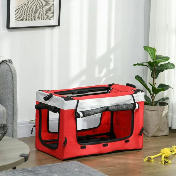 Red pet dog stroller crate with black mesh panels and padded base indoors on floor
