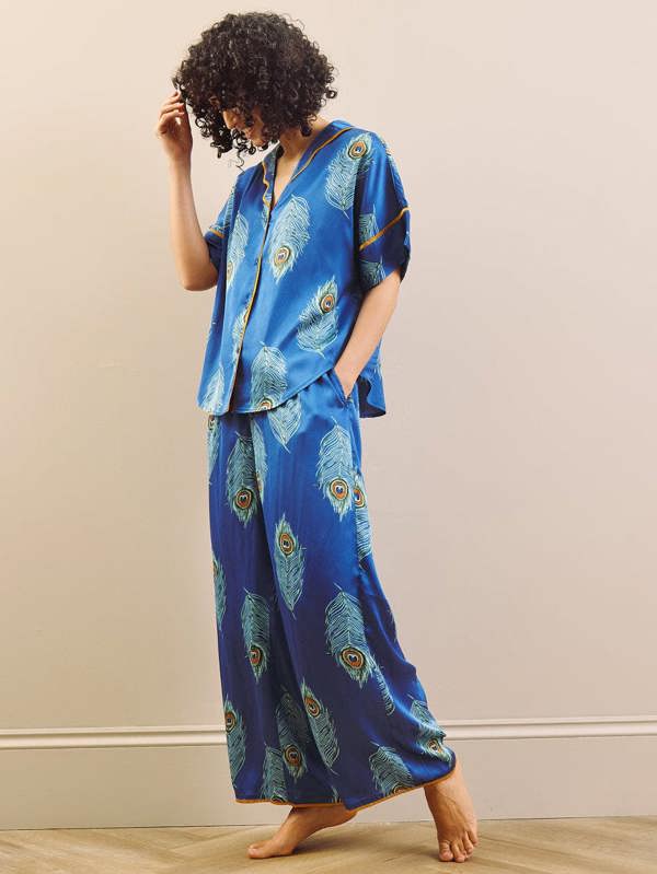 model wears blue long oversized pyjama set with peacock feather design