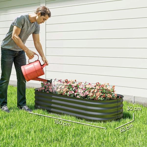 Dark grey raised metal garden bed planter with blooming flowers being watered