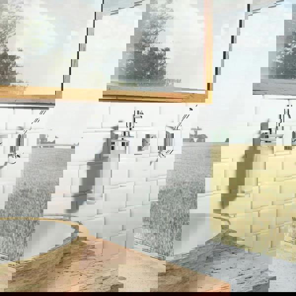 Single polished chrome towel hook on bathroom wall