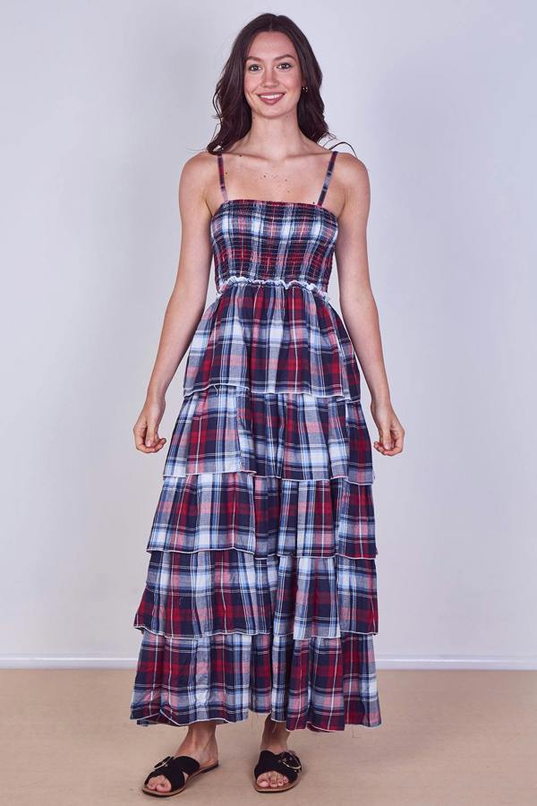 Woman wearing a plaid dress against a plain background