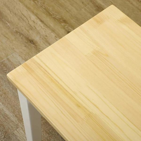 Close-up of light pine tabletop on a white wood bench frame.