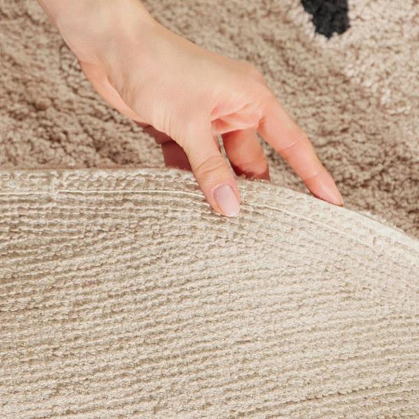 Hand touching a textured surface with a carpeted background
