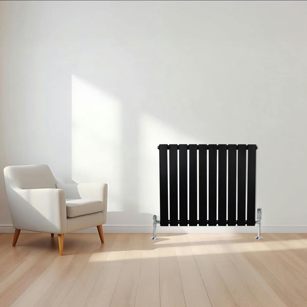 Flat single column radiator in sleek black finish, 600 x 700mm, positioned against a light wall with a modern armchair nearby