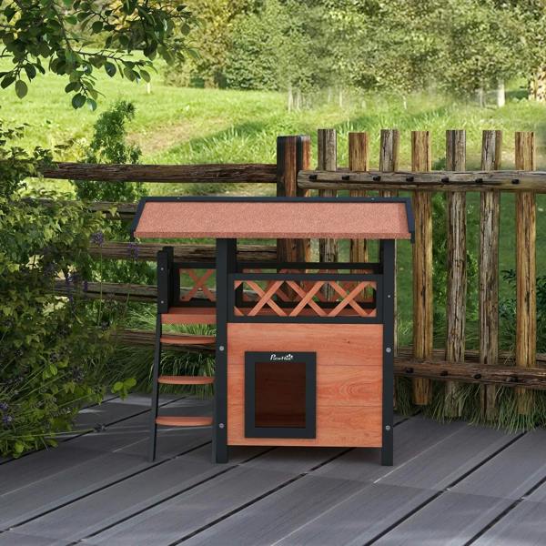 Outdoor cat house on patio with balcony roof and front door; dark frame and brown panels
