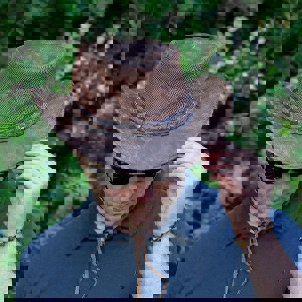 man wearing a wombat the wilds air brown leather hat with mesh sides