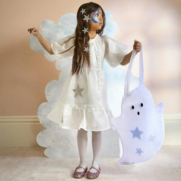 Little girl in a white dress holding a large organza ghost trick or treat bag with silver stars