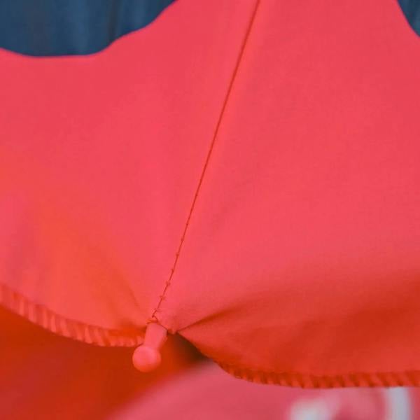 Red parasol canopy seam with small hanging cord and button detail