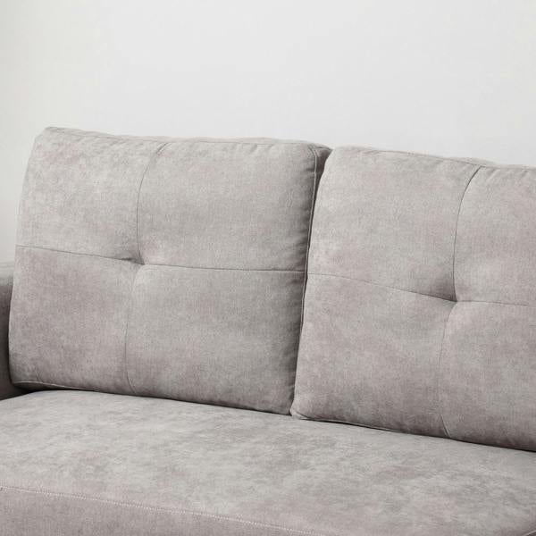 Light grey sofa backrest with three tufted panels and padded arm sections