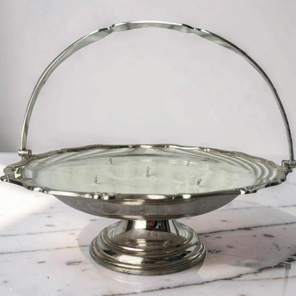 Silver metal basket with a handle on a marble surface
