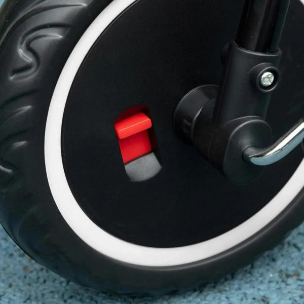 Close-up of black kids tricycle wheel with red safety release button