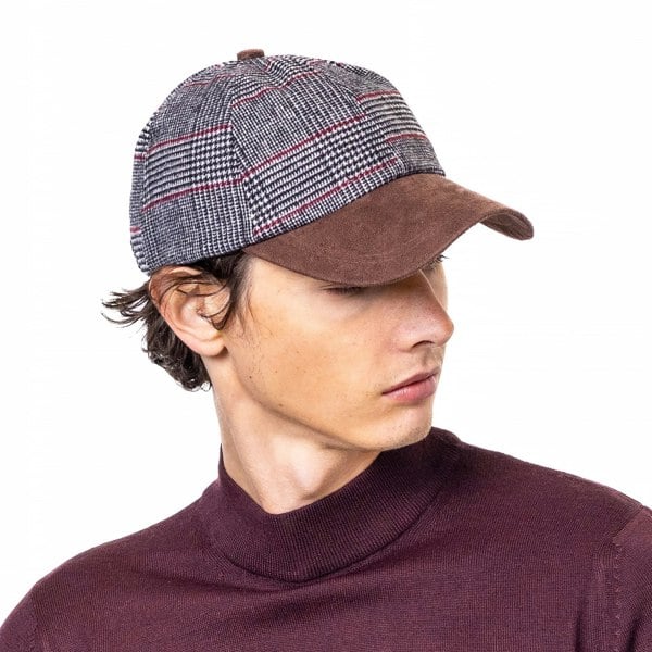 Person wearing a checkered cap with a brown brim on a white background