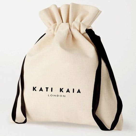 Kati Kaia branded beige drawstring pouch with black ribbons for Selene purity mala bracelet packaging