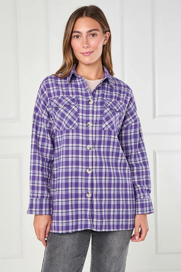 Woman wearing a purple plaid shirt against a white background